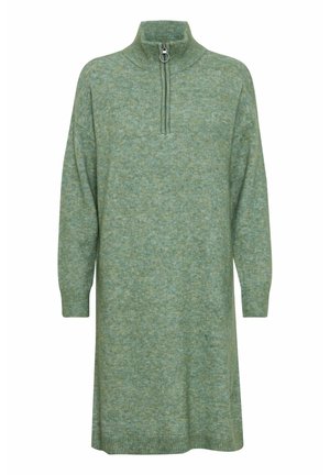 Robe en tricot de couleur vert pâle avec un col haut, fermeture à demi-glissière et manches longues ; elle présente un tissu doux et texturé avec un motif mélangé.