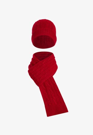 Ensemble bonnet et écharpe rouges en tricot, présentant une texture côtelée et un motif torsadé, offrant chaleur et confort par temps froid.