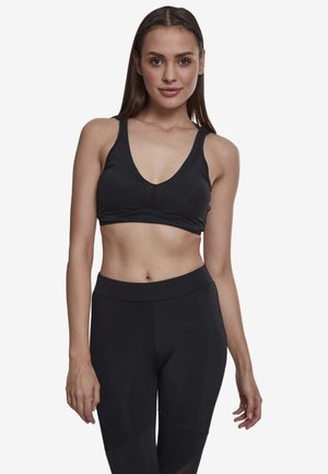 Schwarzer Sport-BH mit tiefem V-Ausschnitt, aus glattem Material gefertigt. Zu den Highlights gehören minimalistische Nähte und eine unterstützende Struktur.