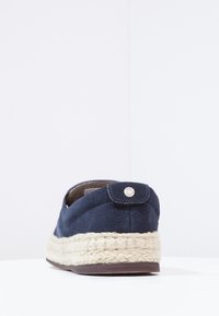 Marinblå mocka espadrillo med en flätad jutesula, rund form, bakre flik med metallaccent och vadderat inre.