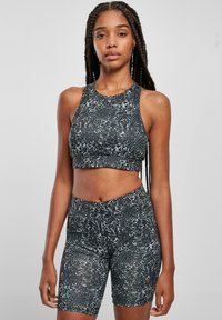 Svart- och vitmarblerad sportuppsättning med en ärmlös crop top och högmidjade shorts, tillverkad av stretchigt, texturerat tyg.