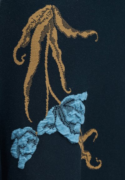 Μπλε ύφασμα με καφέ μίσχους που μοιάζουν με κληματαριά και κεντήματα λουλουδιών σε υφή ανοιχτού μπλε σε σκοτεινό φόντο.