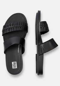 Svarta slidesandaler med texturerad vävd övre rem och slät undre band; vadderad sula; platt sula; minimal design.