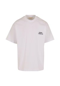Camiseta de algodón blanca con cuello redondo y mangas cortas. Presenta un pequeño texto negro en la parte superior izquierda: "Another Cotton Lab."