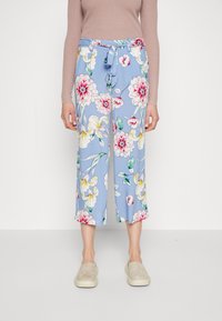 Pantaloni floreali azzurri con vita regolabile, caratterizzati da grandi fantasie floreali rosa e gialle e dalla lunghezza cropped. Tessuto di consistenza liscia.