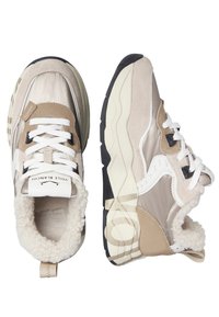 Sneakers atletici beige con parte superiore in suede testurizzato e nylon, lacci bianchi e fodera morbida; suola spessa in gomma con accenti neri a contrasto.