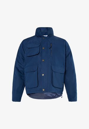 Marineblauwe geïsoleerde jas met een hoge kraag, meerdere zakken en gouden hardware-accenten. Het materiaal lijkt glad en duurzaam.