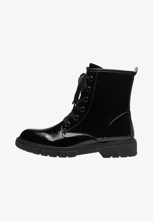 Bottine en cuir noir brillant avec une semelle épaisse et crantée, six œillets avec des lacets noirs, et une languette à l'arrière.