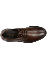 Chaussure en cuir marron avec une finition lisse, bout rond, design à six œillets avec lacets, et semelle intérieure rembourrée. La marque est visible à l'intérieur.