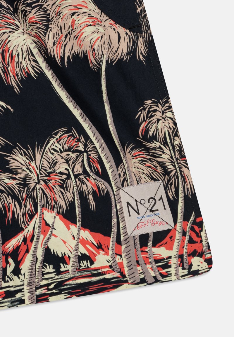 Schwarzer Stoff mit Palmen- und Bergmotiven in Beige- und Rottönen. Enthält ein rechteckiges Etikett mit dem Text "N°21".