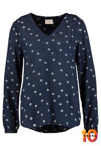 Blusa navy de manga larga, con escote en V y patrón floral blanco. Tejido ligero, con el dobladillo trasero ligeramente más largo y puños fruncidos.