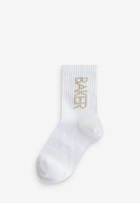 Weißer Baumwollsocken mit gerippter Textur und verstärktem Zehenbereich, mit "BAKER" in metallic-goldenen Buchstaben an der Seite.