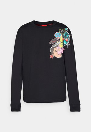 Maglietta nera a maniche lunghe in cotone, con colorati toppe grafiche raffiguranti volti e disegni sul davanti e sull'area della spalla destra.