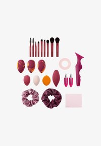 Makeup application set including red-handled brushes, various sponges in pink, marbled, and solid colors, two scrunchies, tape, and a tool.