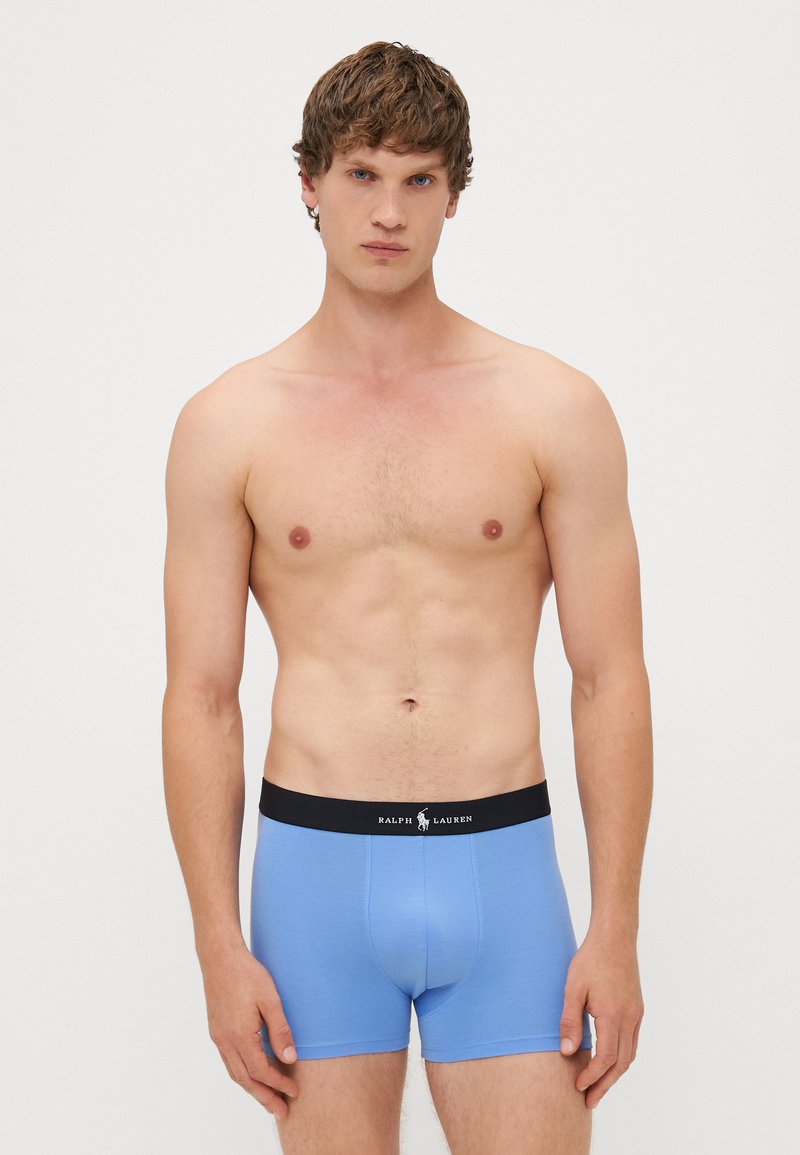Blauwe boxershorts voor heren, gemaakt van rekbare stof, met een zwarte tailleband waarop het "RALPH LAUREN" logo staat. Glad textuur, aansluitend ontwerp.