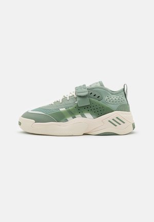 Lage groene sneaker met witte zool, geperforeerd zijpaneel, veters aan de voorkant en een brede klittenbandsluiting over het bovenwerk.