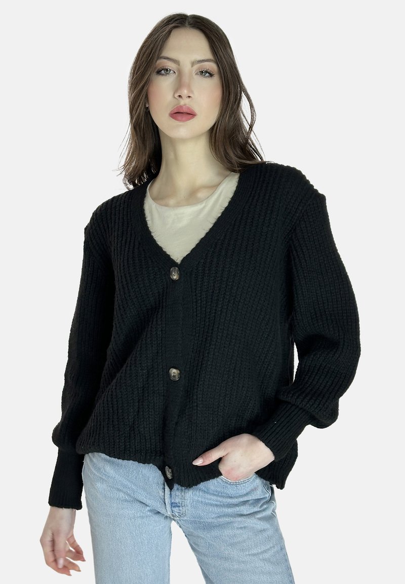 Cárdigan negro de punto con escote en V, botones frontales y corte relajado. Presenta una textura en la tela y mangas largas. Usado sobre una blusa clara.