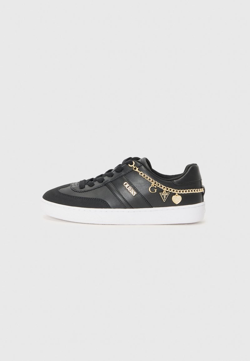 Svart sneaker laget av lær og tekstil, med hvit såle, gullkjede-detaljer og logo på siden.