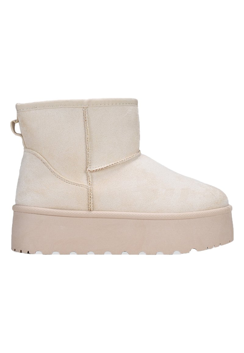 Botines de ante beige con punta redonda, una textura suave y una suela de plataforma gruesa que presenta un diseño de banda de rodadura ondulada.