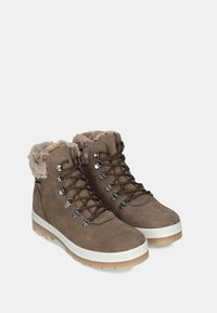 Bottes de randonnée en suede marron avec une bordure en fausse fourrure, des œillets en métal et des lacets. Semelle intermédiaire épaisse blanche avec une semelle extérieure en caoutchouc texturé pour une meilleure adhérence.
