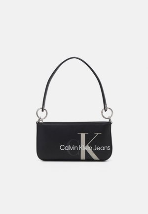 Zwarte rechthoekige schoudertas met zilverkleurige ringen bij de riemaansluitingen en het "Calvin Klein Jeans"-logo in grijs en wit aan de voorkant.