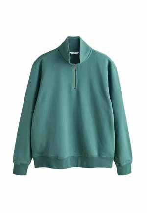 Zelena majica s četrtinsko zadrgo in dolgimi rokavi, narejena iz mehkega mešanega bombažnega materiala. Ima visok ovratnik ter rebraste manšete in rob.