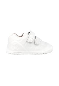 Zapatos blancos para niños hechos de un material sintético suave. Cuentan con dos correas de velcro, una punta redondeada y una suela de goma texturizada.