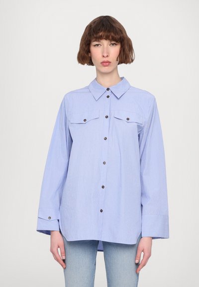 Blauw gestreepte knoopse blouse met een kraag, lange mouwen, twee borstzakken en bruine knoopaccenten. Gemaakt van lichte stof.