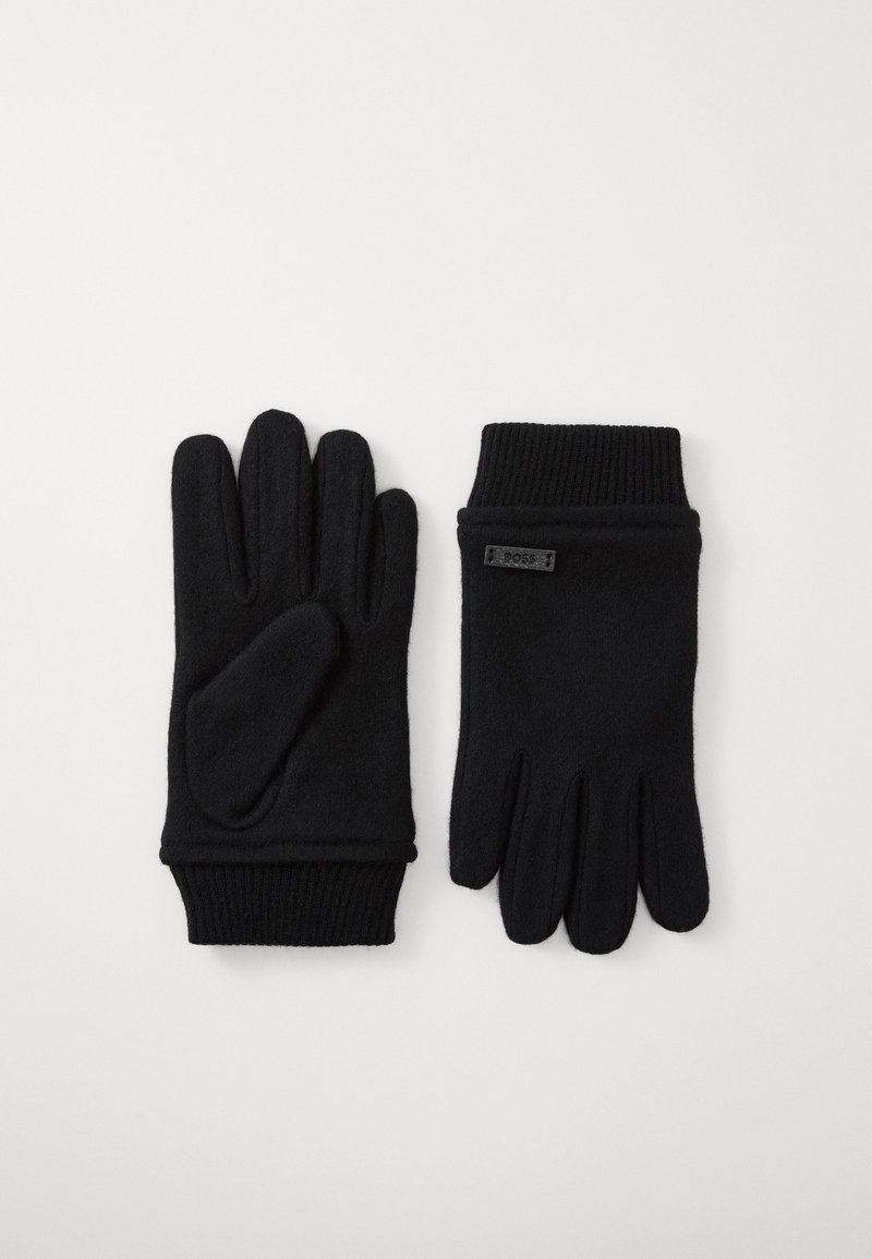 Luvas de malha pretas com cinco dedos, punho canelado, textura macia e um pequeno rótulo de marca numa das luvas. Adequadas para uso em clima frio.
