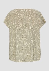 Beige top gemaakt van zachte stof, met een losse pasvorm, afhangende schouders en een patroon van onregelmatige witte stippen.