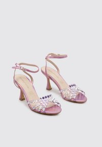 Sandalias de tacón de satén moradas con una correa en el tobillo, que presentan adornos de rhinestones dispuestos en un diseño entrecruzado en la parte delantera.