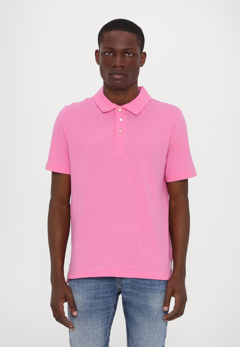 Polo shirt pour homme à manches courtes en rose vif, fabriqué en coton doux, avec un col classique, une patte de boutonnage à trois boutons et des fentes latérales discrètes.