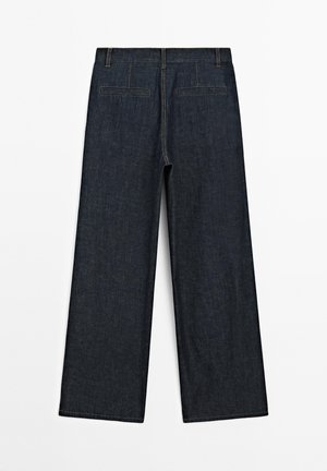 Pantaloni in denim blu scuro a gamba ampia con una texture liscia, dotati di due tasche posteriori e cuciture a contrasto lungo le cuciture.