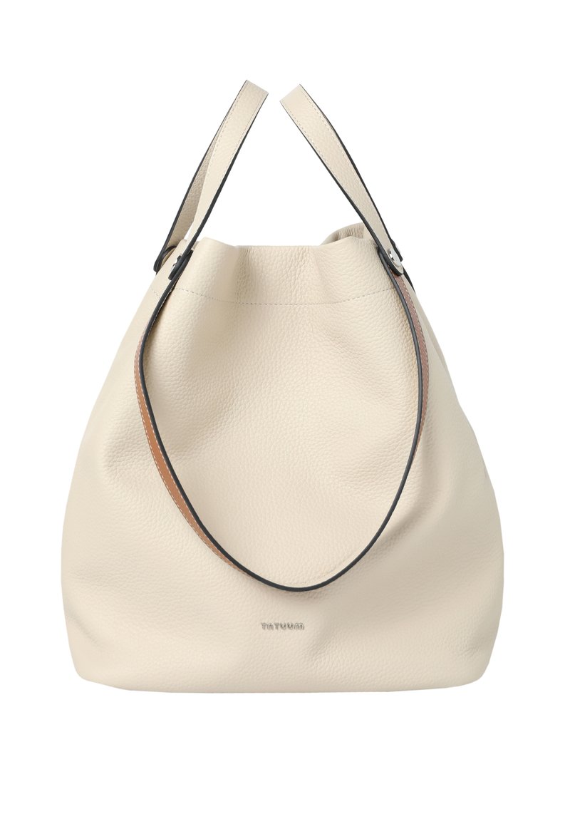 Ecrufarbene Ledertasche mit strukturierter Oberfläche, schwarzen und braunen Trägern sowie minimaler Markenkennzeichnung auf der Vorderseite. Weiche, abgerundete Form.