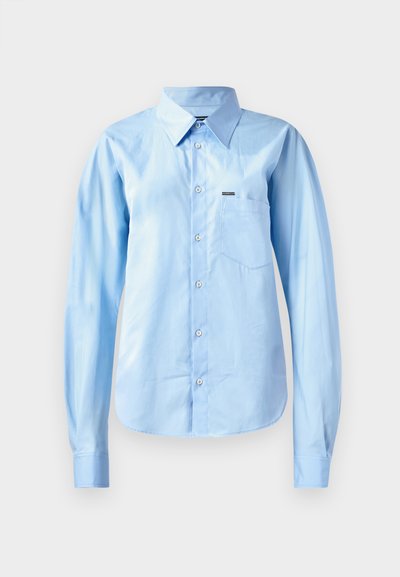 Light blue button-up shirt in smooth fabric with long sleeves, structured collar, single chest pocket, and subtle branding detail.