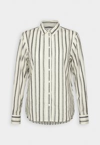 Chemise blanche boutonnée à manches longues avec motif chevron noir rayé vertical, présentée à plat sur fond blanc.