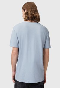 T-shirt in cotone azzurro chiaro con maniche corte, vestibilità rilassata e scollatura rotonda. Il tessuto sembra leggermente texturizzato e informale.