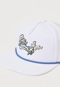 Bijela kapa s ravnim vizirem i plavim akcentnim trakama. Ima šarena grafika karakternog zmaja koji nosi šešir, s detaljnim linijama.