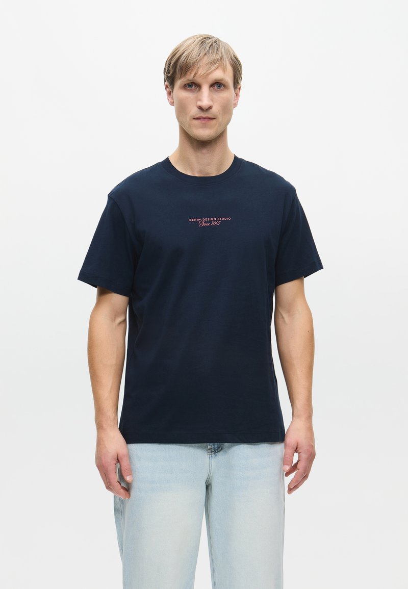 Ναυτικό μπλε βαμβακερό t-shirt με κοντά μανίκια, κλειστή λαιμόκοψη και εκτυπωμένο κείμενο "DENIM DESIGN STUDIO Since 2007" στο στήθος.
