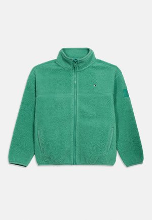 Πράσινο φλις μπουφάν με ολόκληρο φερμουάρ, ψηλό γιακά, πλαϊνές τσέπες και μικρό λογότυπο στο στήθος και το μανίκι.