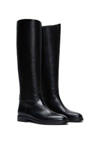 Bottes noires en cuir montantes avec une texture lisse, bout rond, design minimaliste et un petit talon carré.