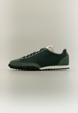 Тъмнозелен и черен маратонка Nike с бяла междинна подметка, черни връзки и текстурирана подметка, показани отстрани на неутрален фон.