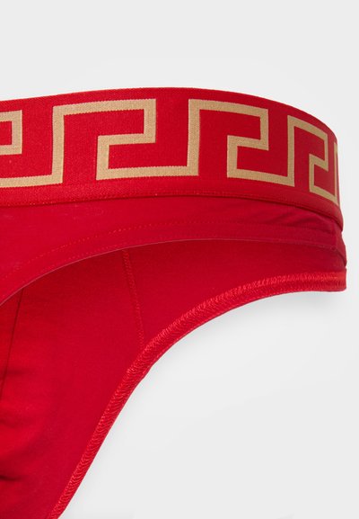 Rote Unterwäsche mit einem breiten goldenen griechischen Schlüsselmuster am Bund. Weicher Stoff, glatte Textur und konturierte Form für eine enganliegende Passform.