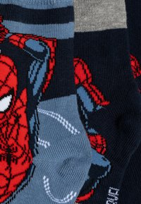 Calzini a tema Spider-Man con grafiche del personaggio rosse, strisce blu navy e grigie, materiale in cotone misto e texture a coste.