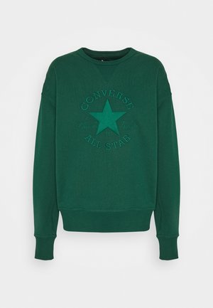 Grön sweatshirt i mjukt tyg med en präglad stjärndesign och texten "Converse Chuck Taylor All Star". Rund hals och ribbad mudd.