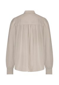 Long-sleeve beige blouse with a collared neck, pleated back, and smocked cuffs. Made from lightweight fabric, featuring a relaxed fit.