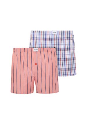 Zwei Paar Jockey-Boxershorts: eines pfirsichfarben mit vertikalen blauen Streifen und einem roten Knopf, eines weiß mit blau-rotem Karomuster.