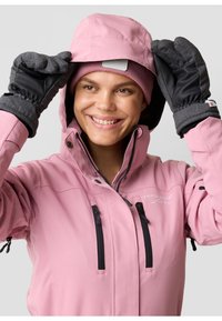 Pink waterproof jacket with multiple zippered pockets, a fitted hood, and gray gloves. The design features black hardware and a logo on the chest.