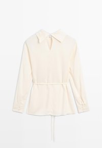 Blouse crème à manches longues avec col, ouverture en goutte d'eau à l'avant et taille à cordon. Texture lisse et poignets boutonnés. Design minimaliste.