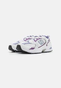 White athletic shoes with purple accents, mesh panels, lacing system, padded collar, and black rubber sole. Features logo on side.